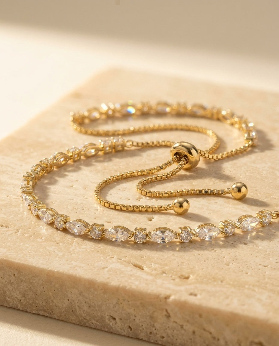 Aria Bracelet macro detail — gold marquise and round stone links with bolo slider clasp on travertine