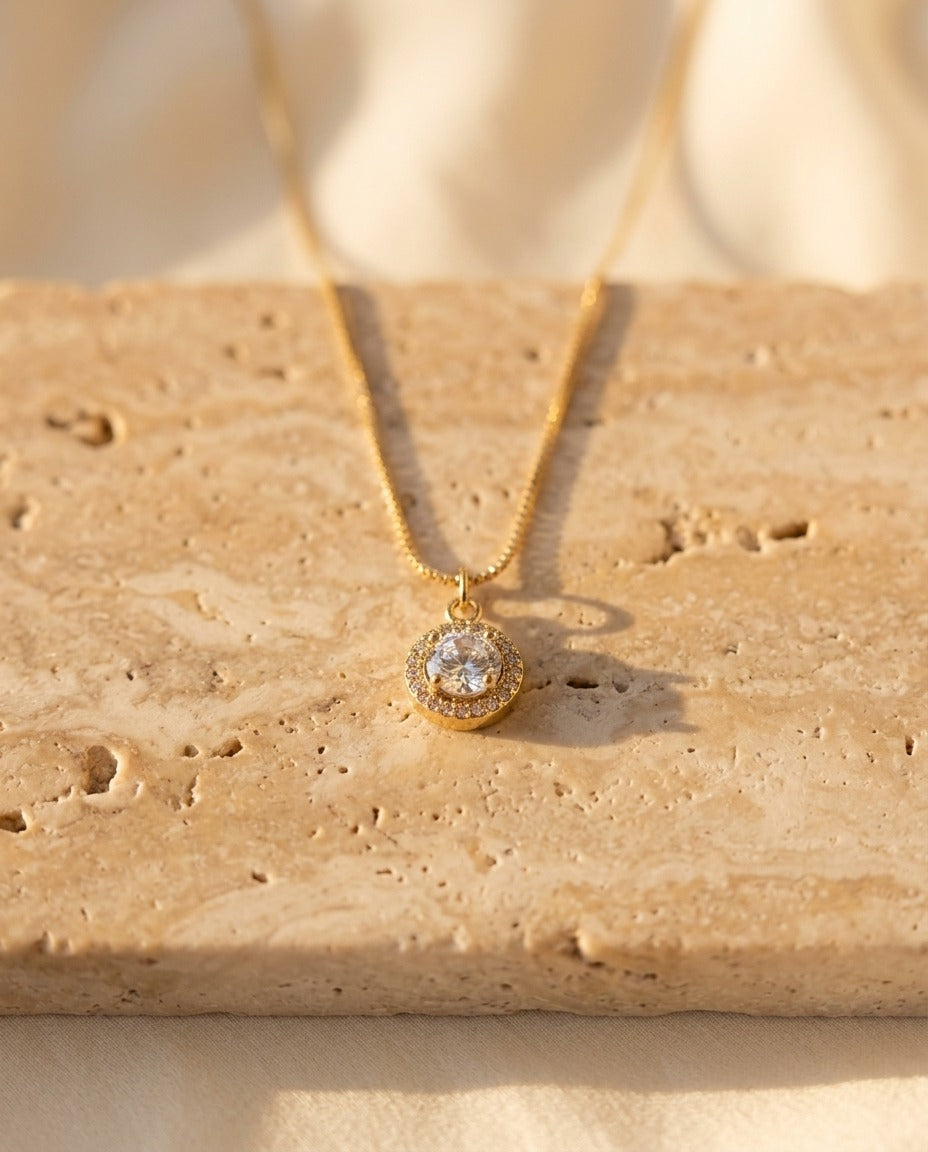 Celina Pendant Necklace in crystal on warm travertine