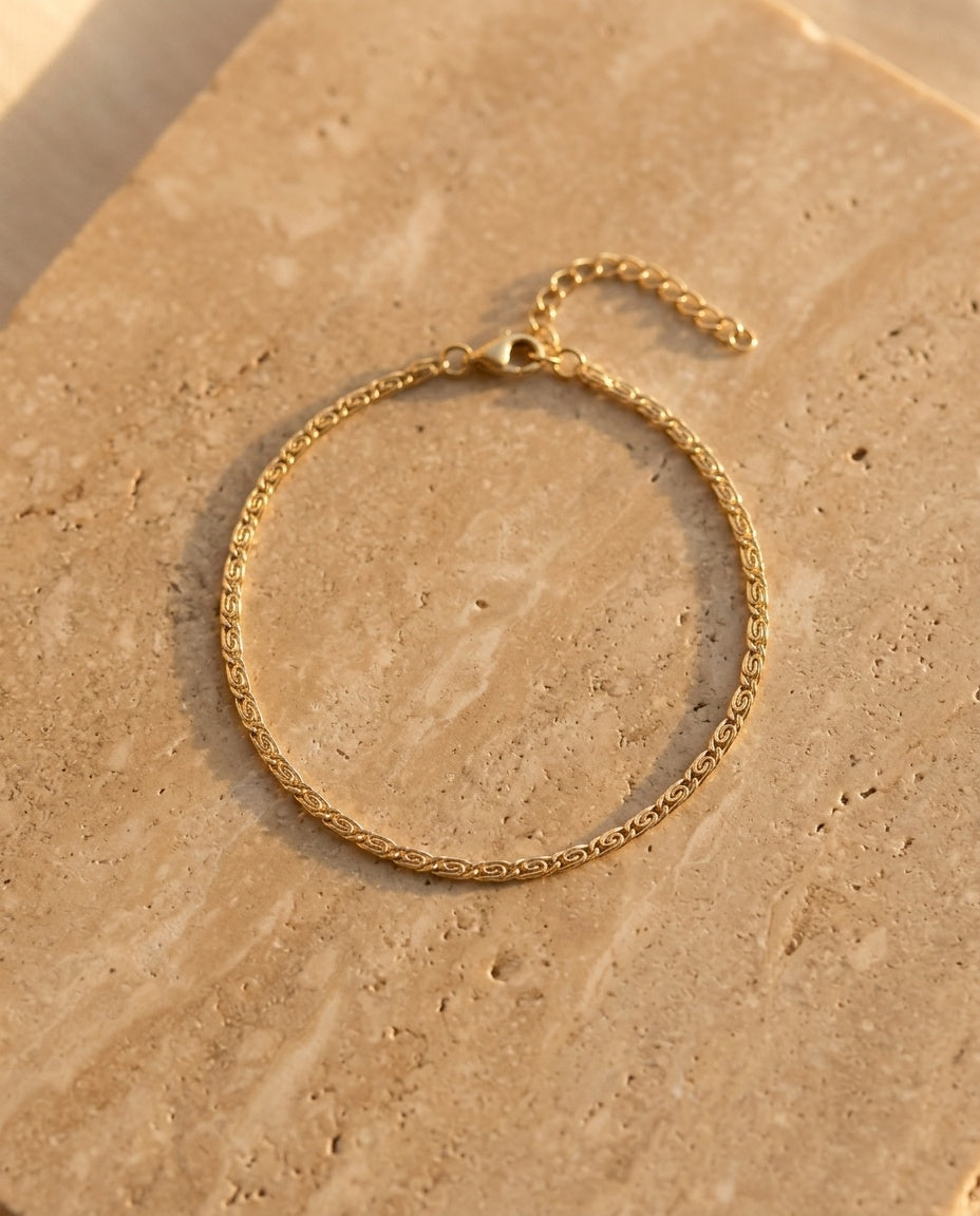 Éclisse Bracelet in gold on warm travertine