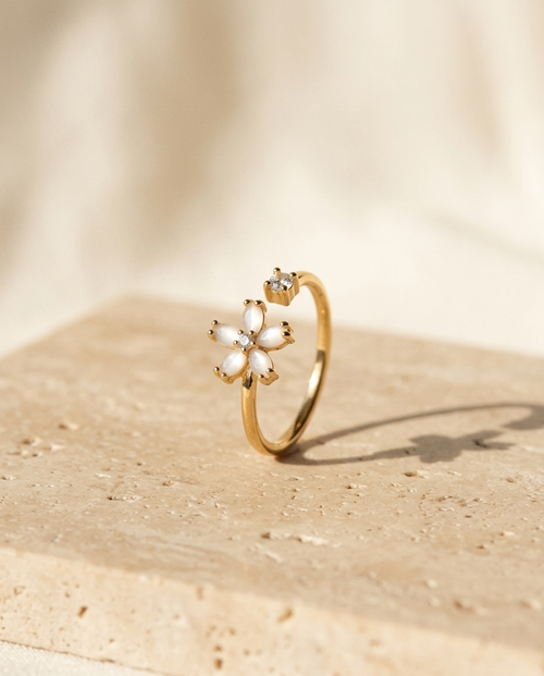 ALTUNA Flora Ring — editorial product photography on warm beige travertine