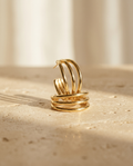 ALTUNA The Muse Hoops — editorial product photography on warm beige travertine