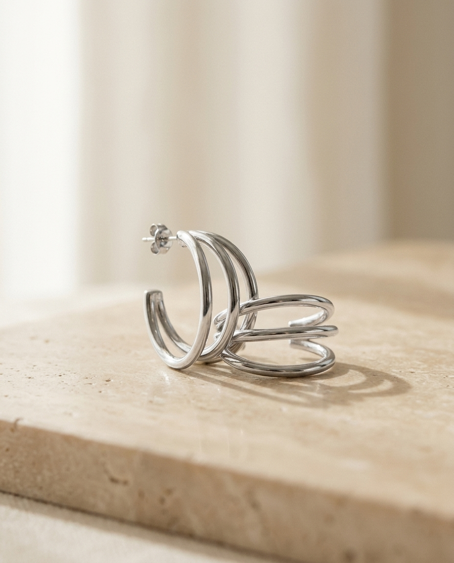 ALTUNA The Muse Hoops in silver — editorial product photography on warm beige travertine