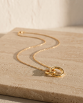 Endless Bond Necklace in gold on travertine