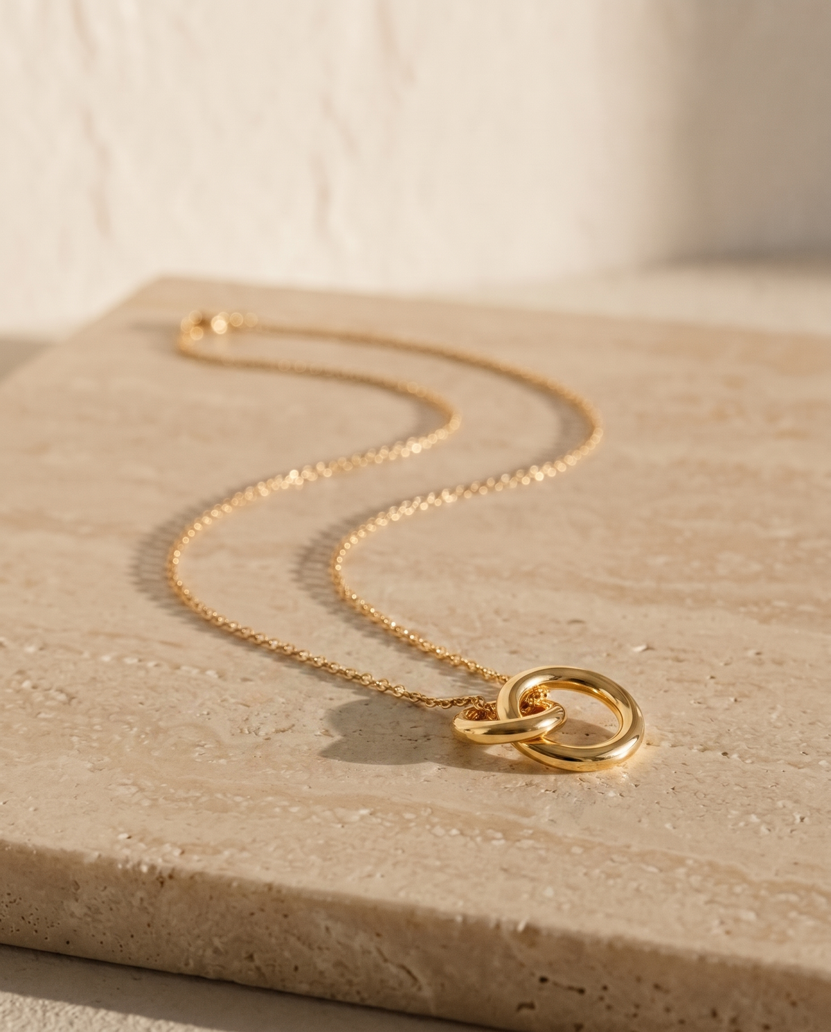 Endless Bond Necklace in gold on travertine