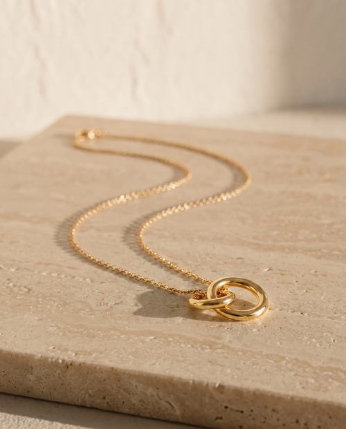 Endless Bond Necklace in gold on travertine