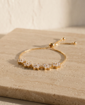 ALTUNA Blossom Bracelet — editorial product photography on warm beige travertine
