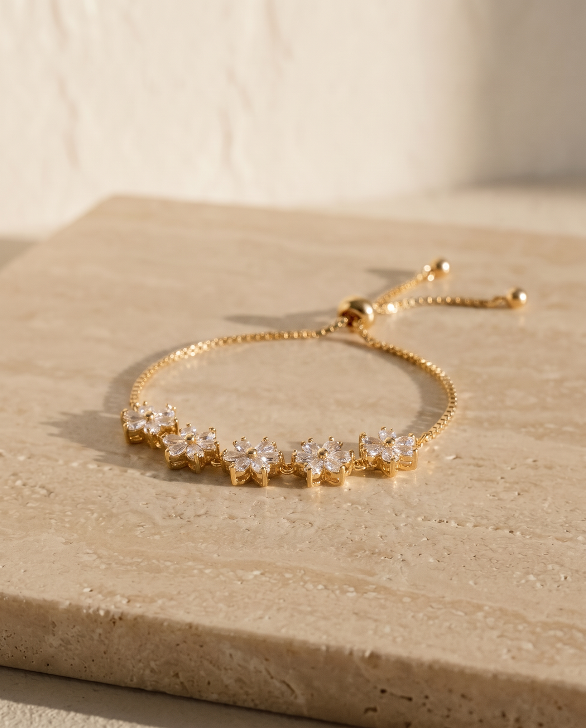 ALTUNA Blossom Bracelet — editorial product photography on warm beige travertine