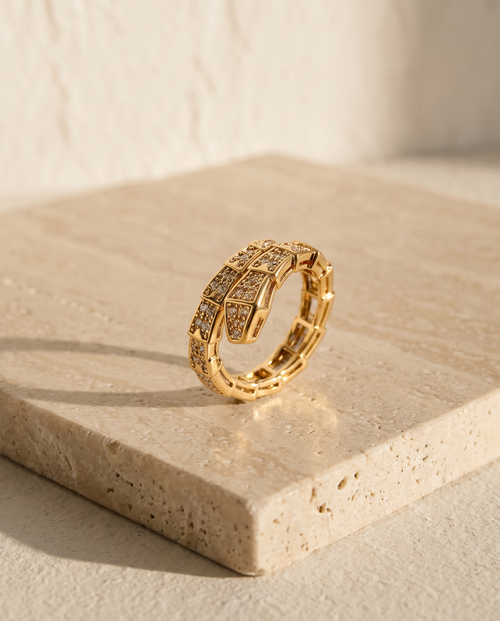 ALTUNA Serpenté Ring — editorial product photography on warm beige travertine