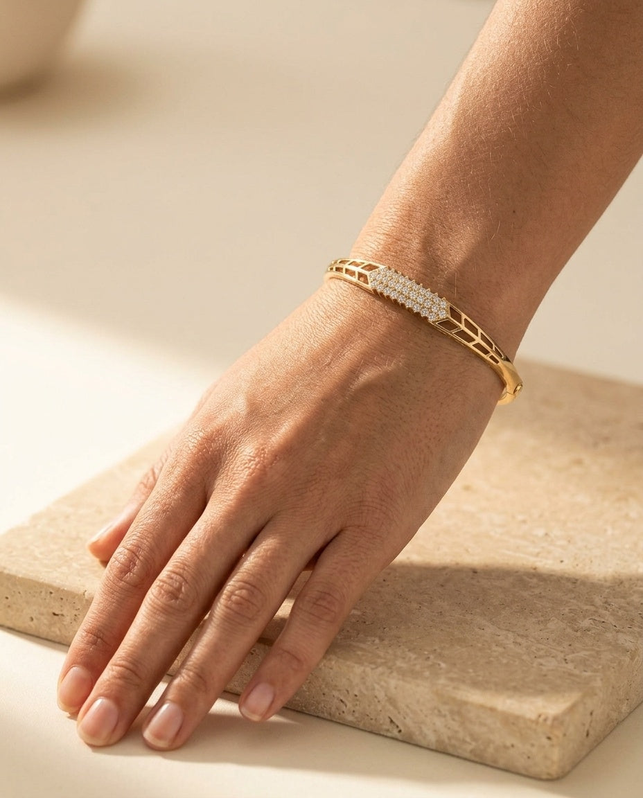 Lucia Bangle worn on a woman's wrist resting on warm travertine in soft golden sunlight