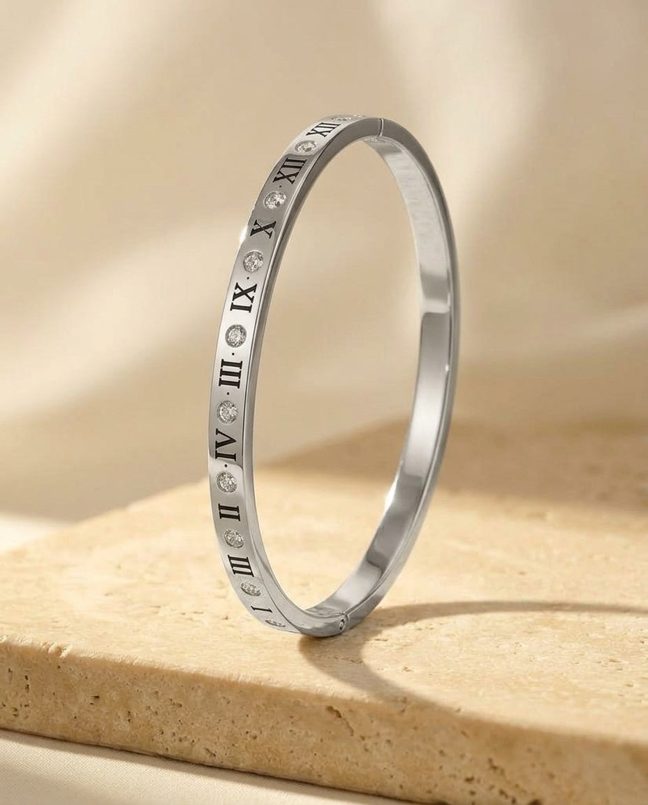 The Roman Éclat Bracelet - macro detail of the engraved Roman numerals and flush-set crystals on the polished silver bangle