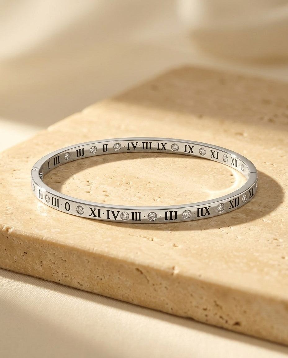 The Roman Éclat Bracelet resting on warm beige travertine in soft golden light