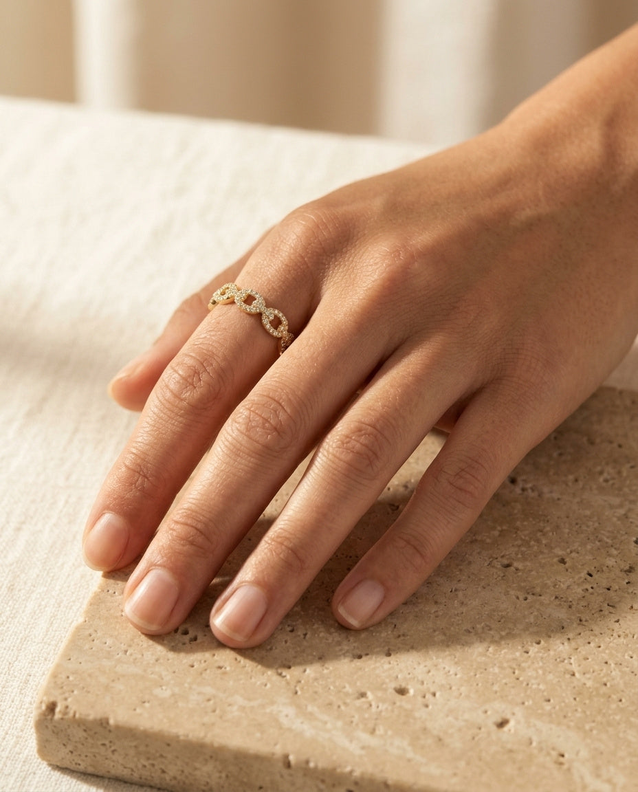 Velique Ring by ALTUNA worn on the hand, pavé gold links in soft natural light