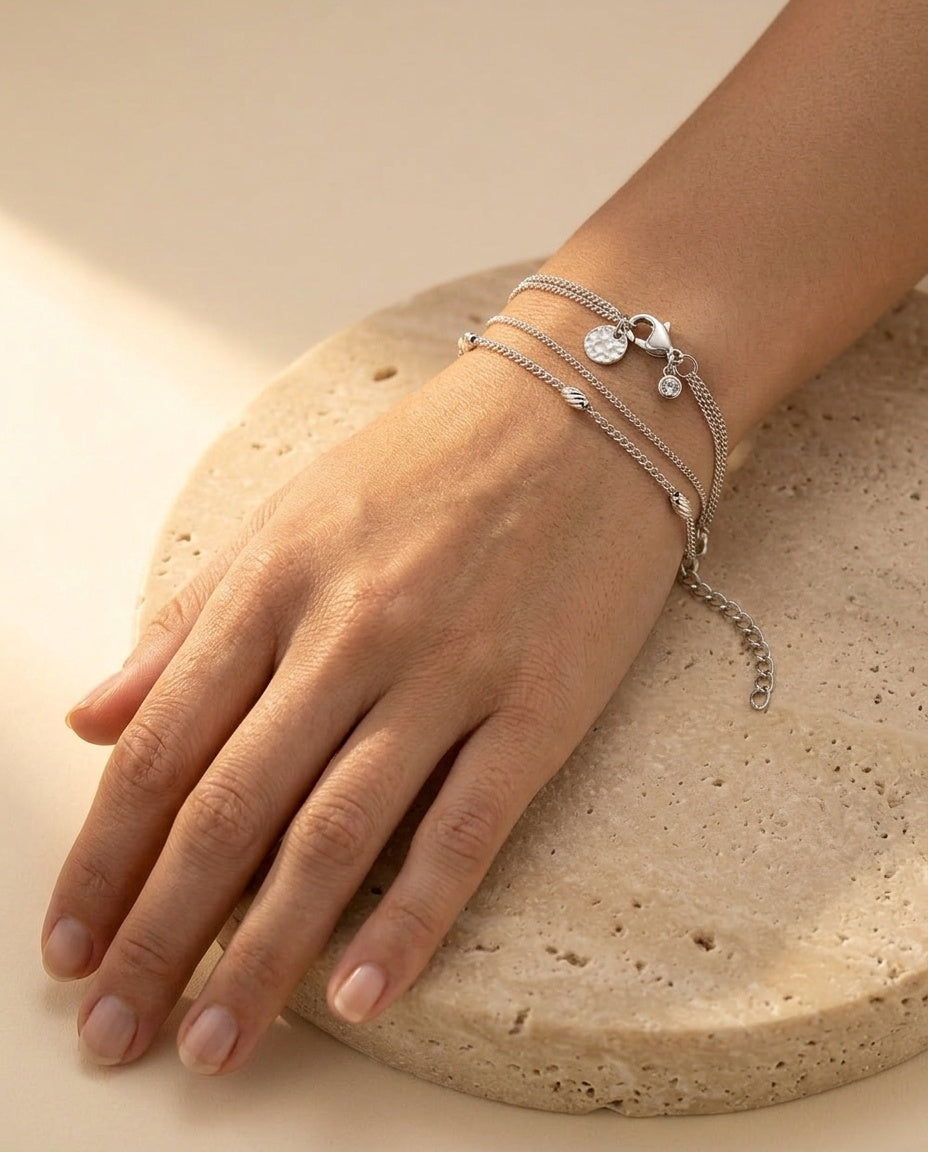 Véra Bracelet worn on the wrist, double-strand silver bracelet draping naturally in warm golden light