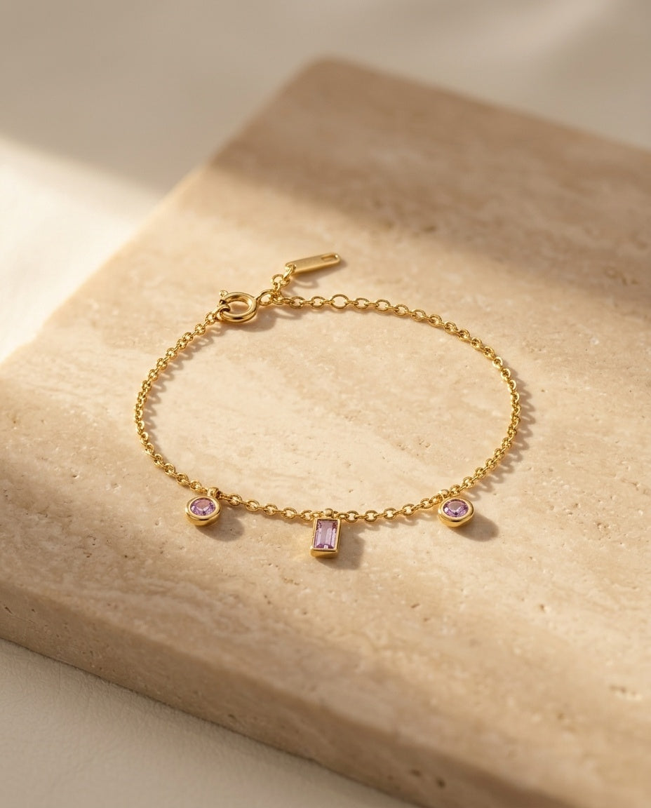 Violet Kiss Bracelet — editorial still life on warm travertine