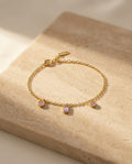 Violet Kiss Bracelet — editorial still life on warm travertine